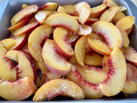 Slice the peaches and place them into the baking dish.